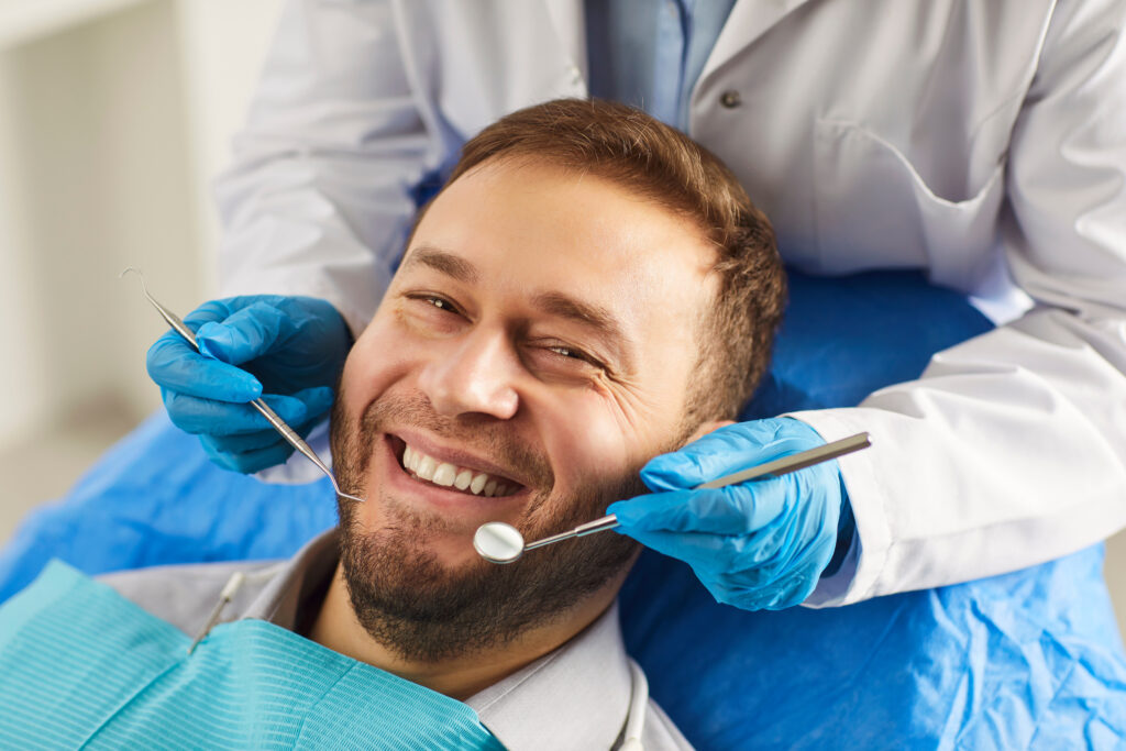 Happy man smiling toothily while being on medical check up in dentistry clinic